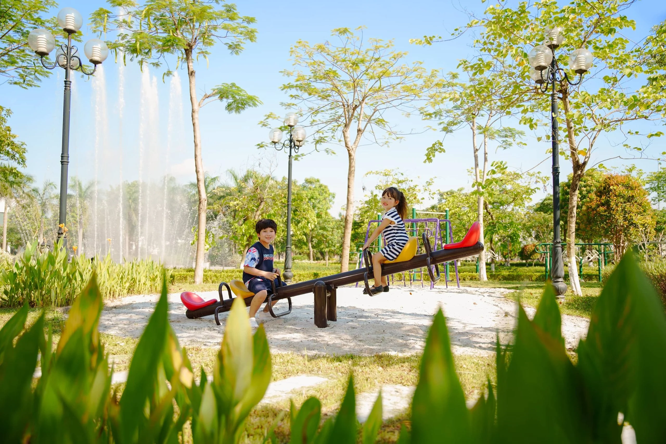 Sân chơi trẻ em giữa công viên có đài phun nước tại Anlac Green Symphony